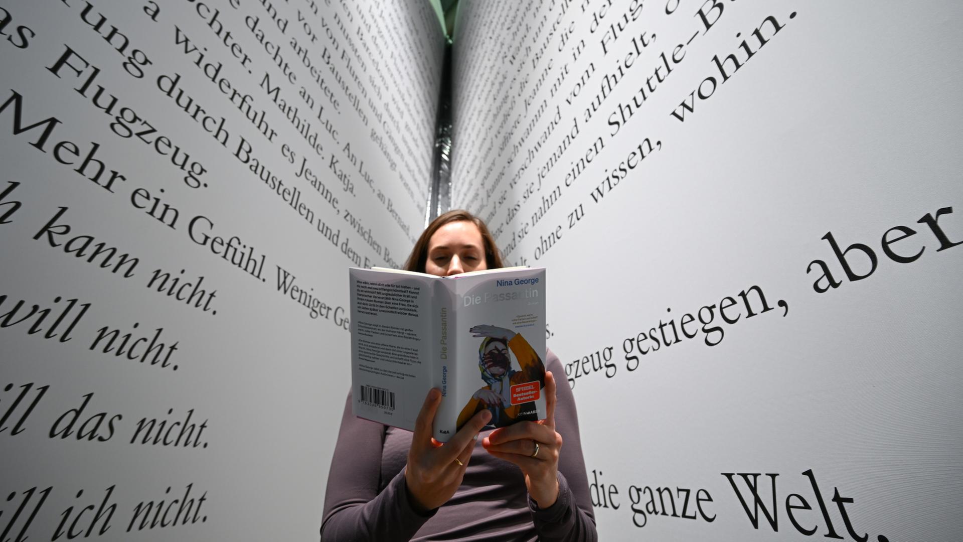 Eine Frau hält ein Buch.  | dpa