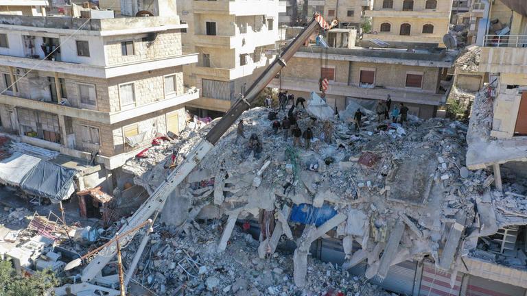 Symbolbild: Ein Foto zeigt Hilfskräfte nach dem Erdbeben am 7. Februar 2023 in den Trümmern eines Hauses in Salkin, Syrien.