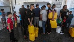 Palästinenser füllen inmitten der durch die israelische Belagerung des Gazastreifens verursachten Wasserkrise Behälter mit Trinkwasser aus einem Wasserverteilungsfahrzeug.