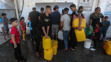 Palästinenser füllen inmitten der durch die israelische Belagerung des Gazastreifens verursachten Wasserkrise Behälter mit Trinkwasser aus einem Wasserverteilungsfahrzeug.