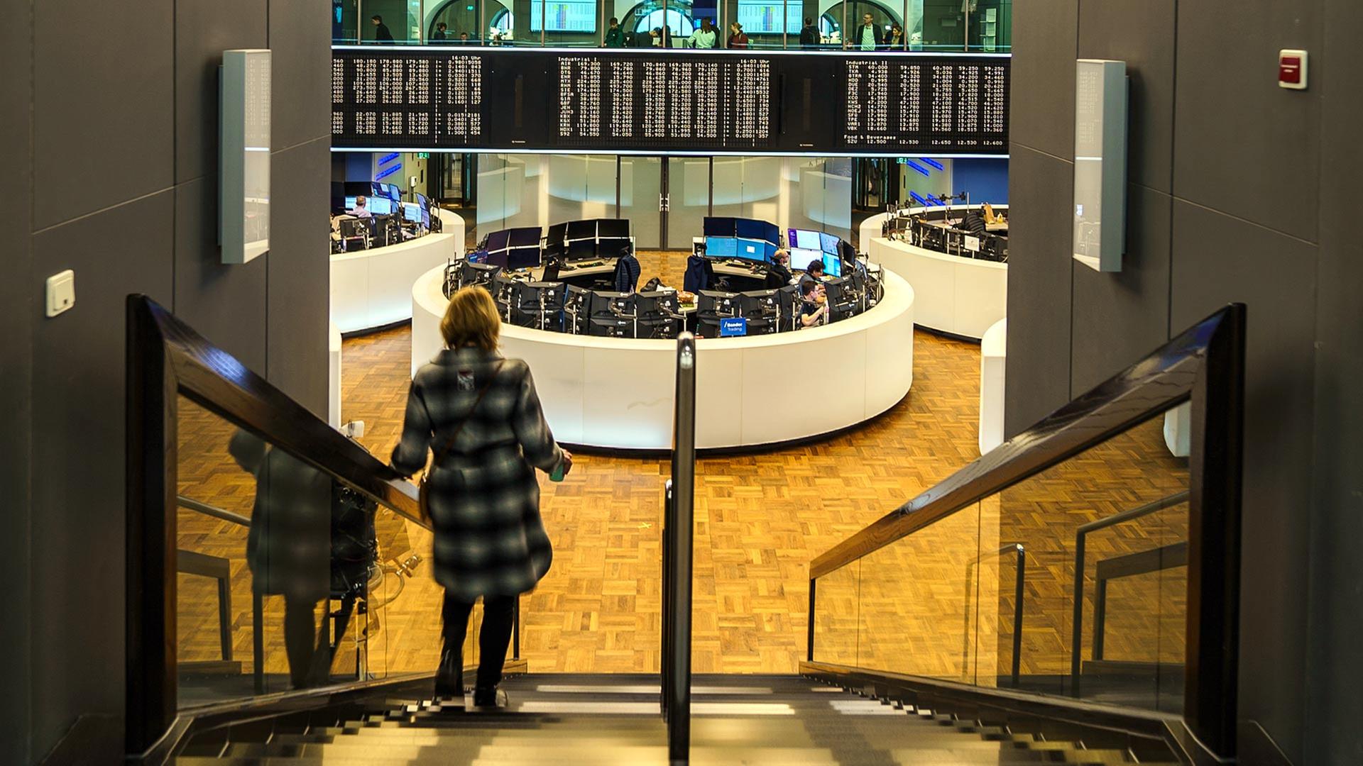 Eine Frau betritt das Parkett der Frankfurter Börse über eine Treppe. | picture alliance/dpa