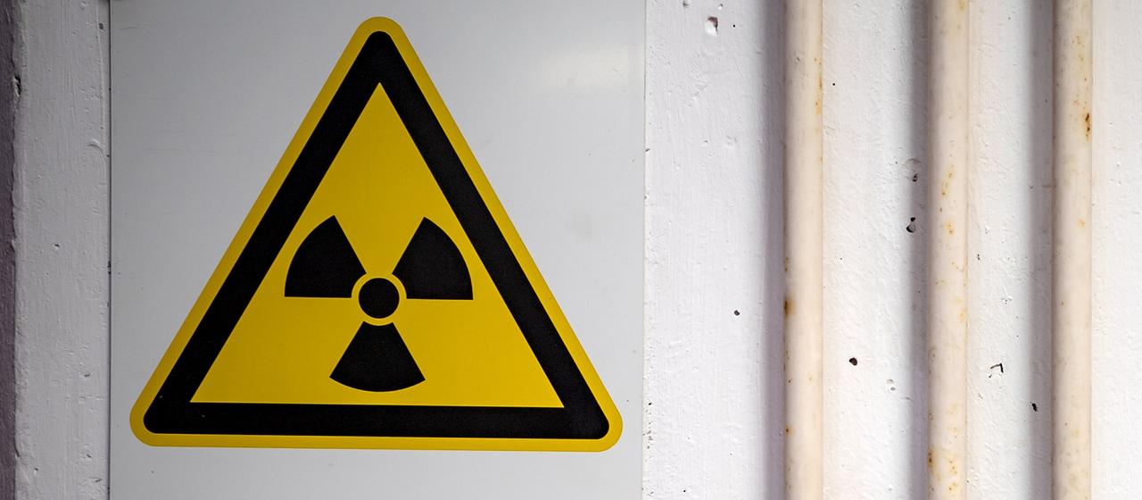 Das Zeichen für Radioaktivität hängt an einer Wand.