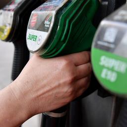 Eine Frau greift nach der Zapfpistole an einer Tankstelle.