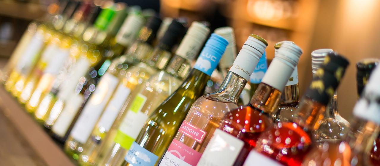 Zahlreiche Weinflaschen stehen in einem Regal.