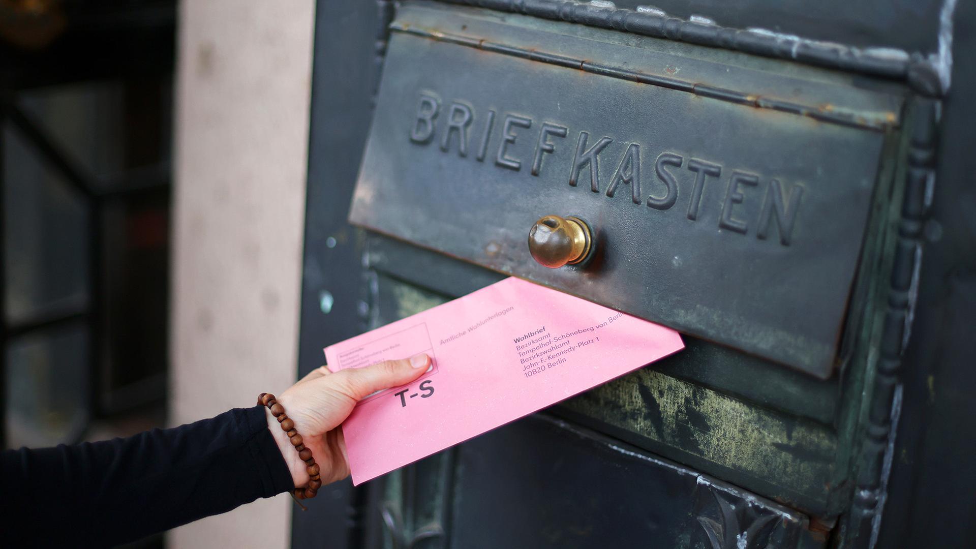 Eine Person wirft ihre amtlichen Wahlunterlagen in einen Briefkasten (Quelle: picture alliance/C.Kadatz) | picture alliance/C.Kadatz