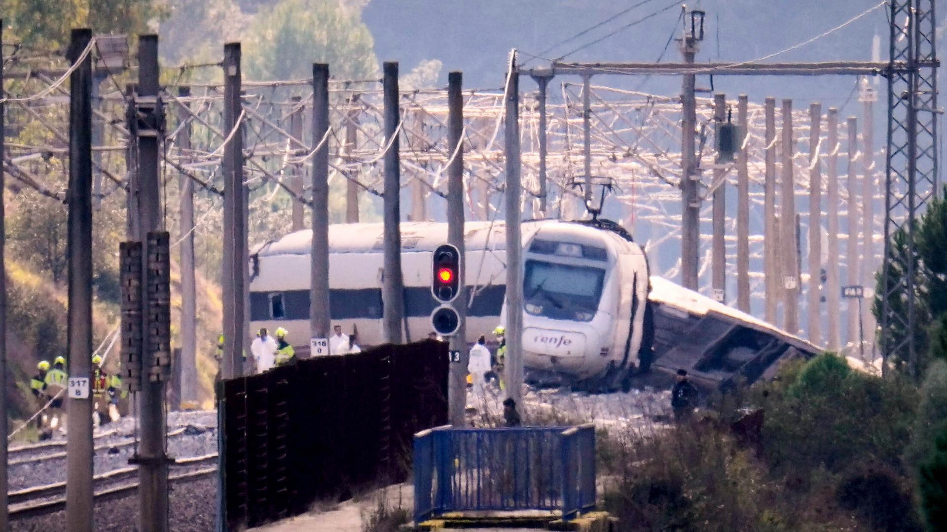 Rettungskräfte arbeiten neben einem entgleisten Zug | dpa