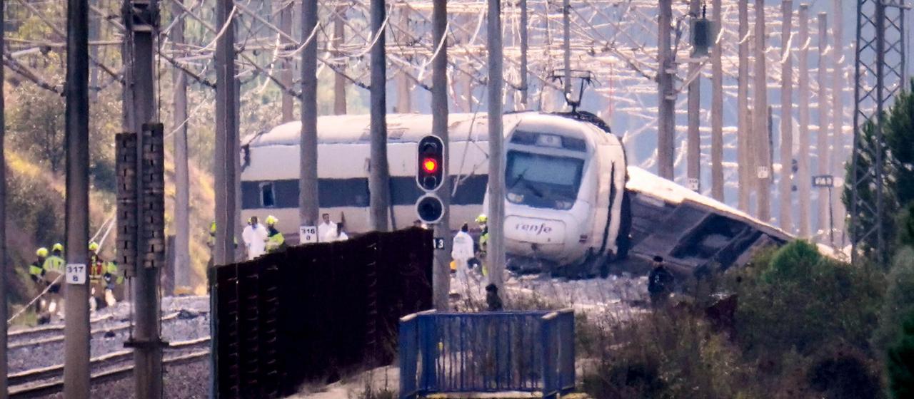 Rettungskräfte arbeiten neben einem entgleisten Zug