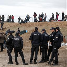 Türkische Polizisten stehen in der Nähe von Migranten nahe der türkisch-griechischen Grenze.