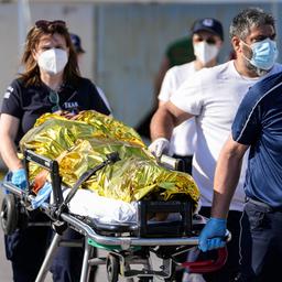 Sanitäter tragen einen verletzten Überlebenden eines Schiffsunglücks zu einem Krankenwagen im Hafen der Stadt Kalamata.