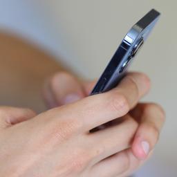 Ein Jugendlicher hält ein Smartphone in den Händen.