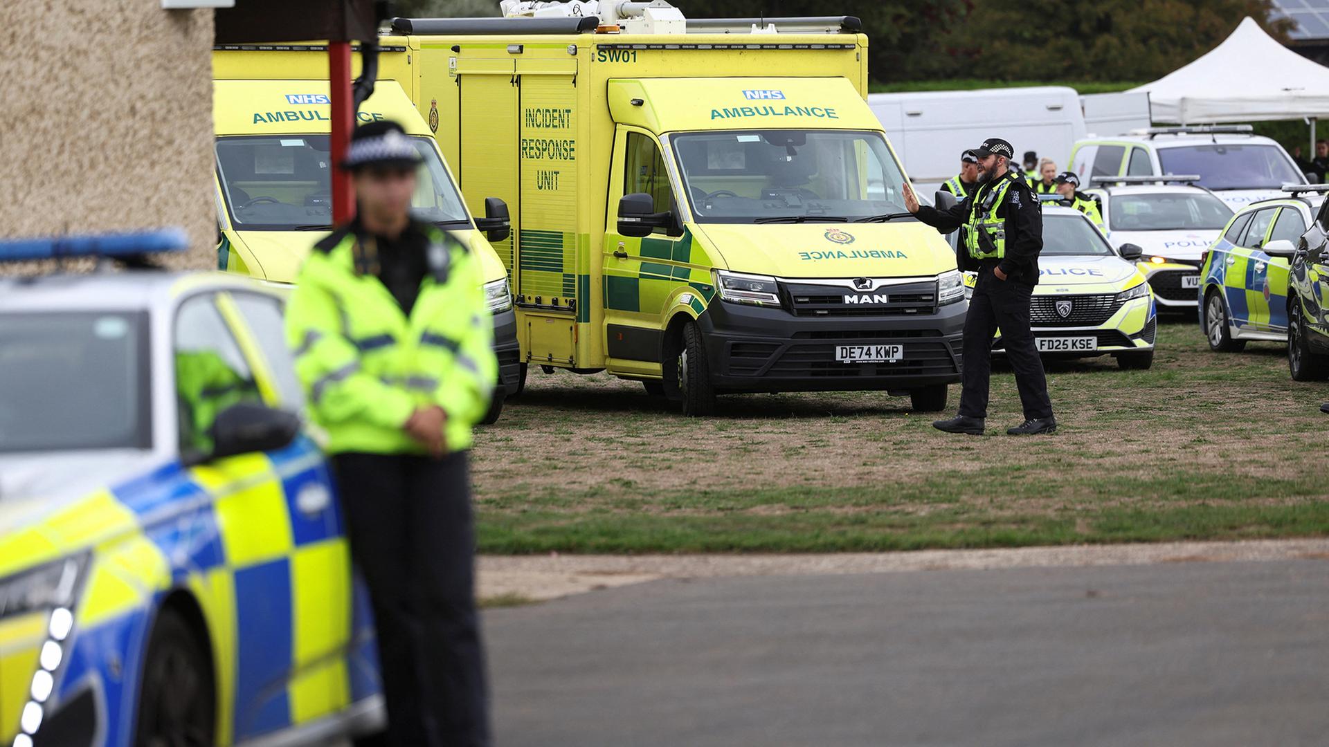 Britische Polizisten befinden sich in der Nähe ihrer Fahrzeuge und Rettungswagen. | REUTERS