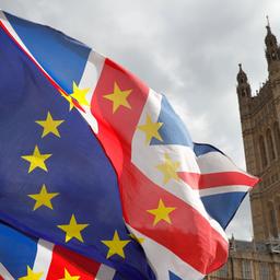 Europäische und britische Flaggen vor dem Parlament in London.