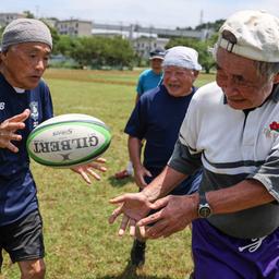 Eine Gruppe alter Japaner spielt Rugby