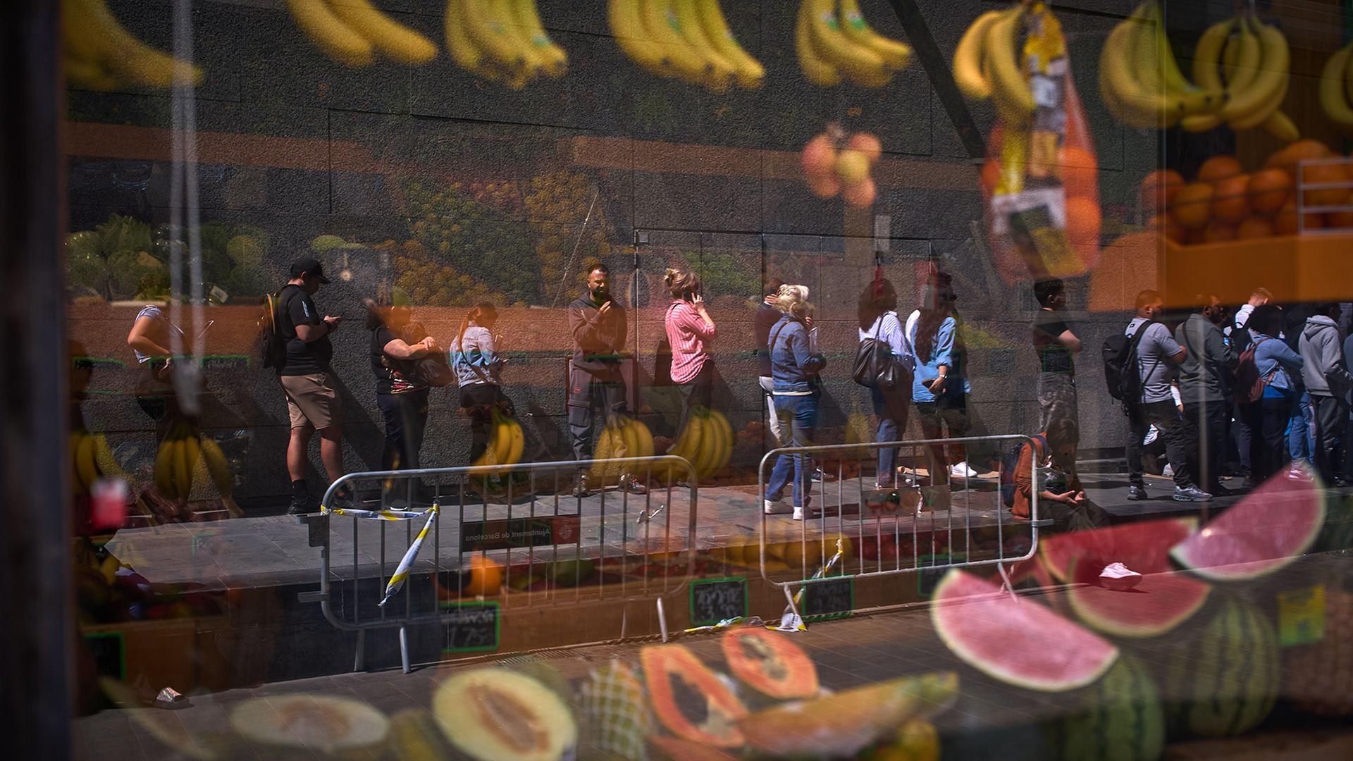 Migranten stehen vor dem Rathaus von Barcelona Schlange. | Emilio Morenatti/AP/dpa