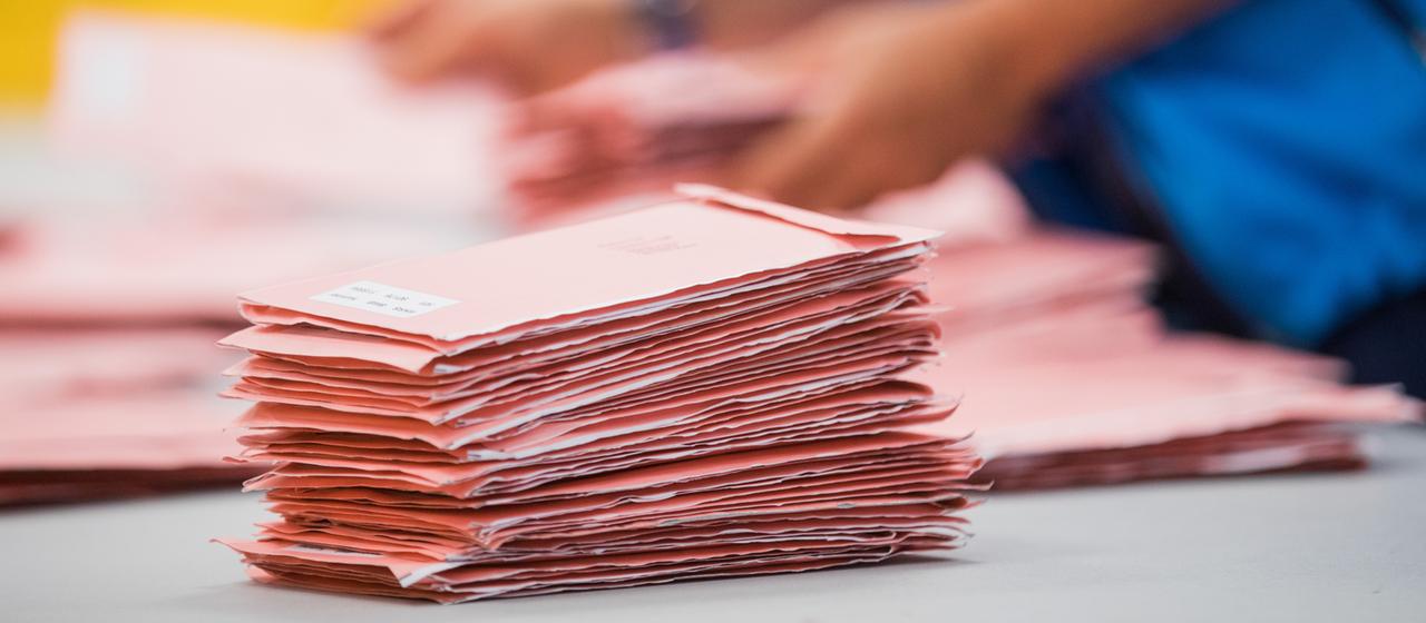 Wahlhelfende sortieren die roten Wahlbriefe mit den abgegebenen Stimmen für die Bundestagswahl 2017.
