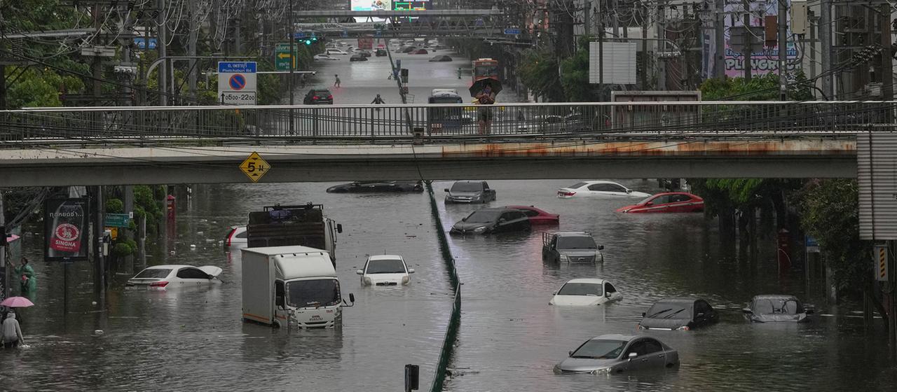 Autos befinden sich auf einer überfluteten Straße.