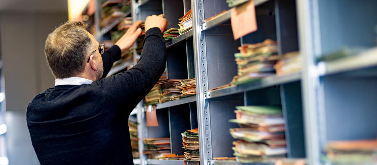 Ein Verwaltungsangestellter sortiert Akten.