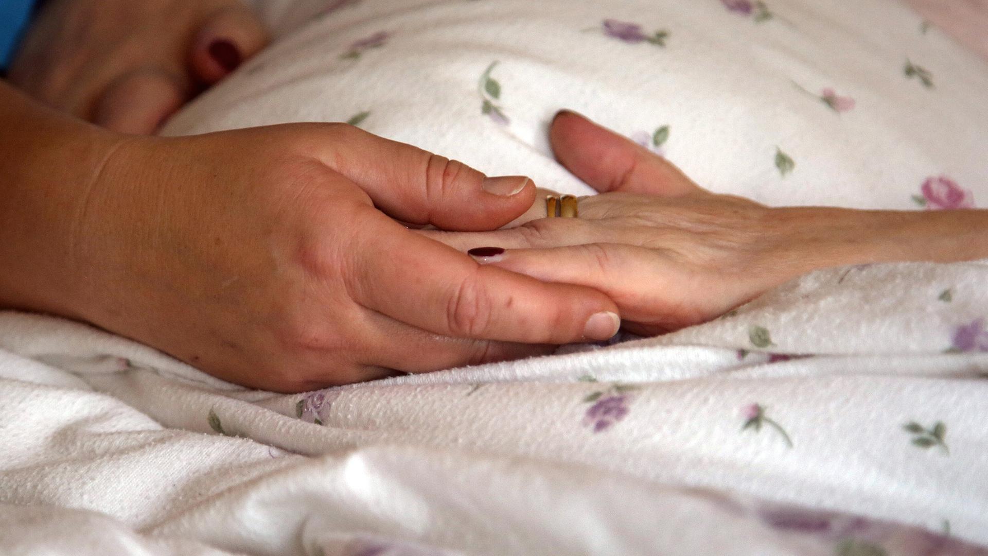 Symbolbild: Die H�nde einer Bewohnerin liegen in einem Hospiz auf einer Bettdecke (Quelle: picture alliance/dpa/P.F�rster) | picture alliance/dpa/P.F�rster