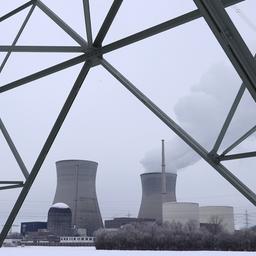Kühltürme eines Atomkraftwerkes stehen hinter Strommasten.