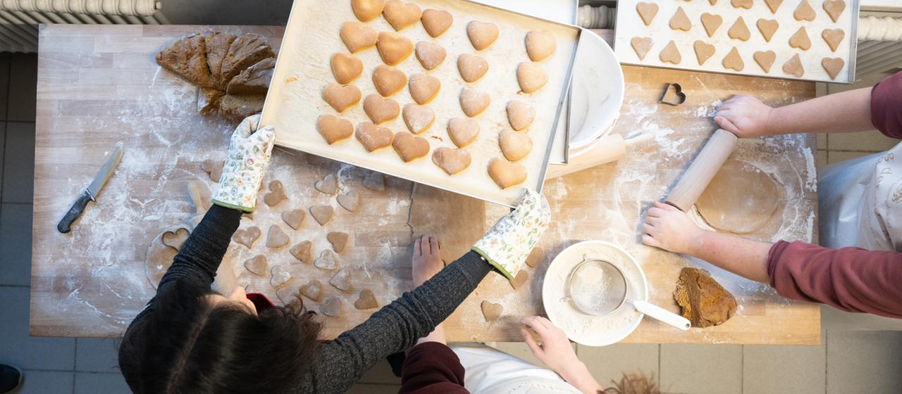 Jugendliche backen Plätzchen in einer Backstube.
