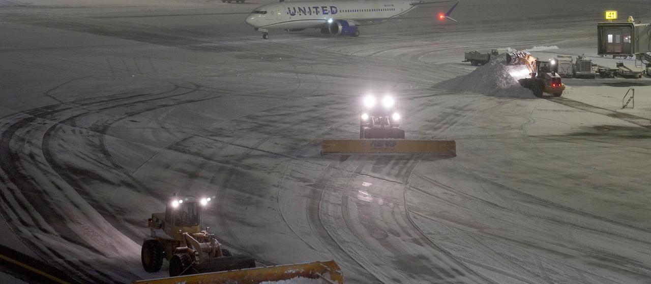 Schneepflüge räumen das Vorfeld am Flughafen in New York