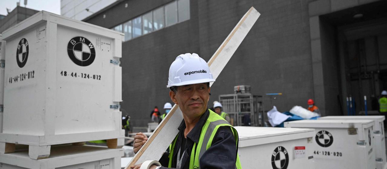 Arbeiter bauen für BMW den Stand bei der Automesse in Peking auf.