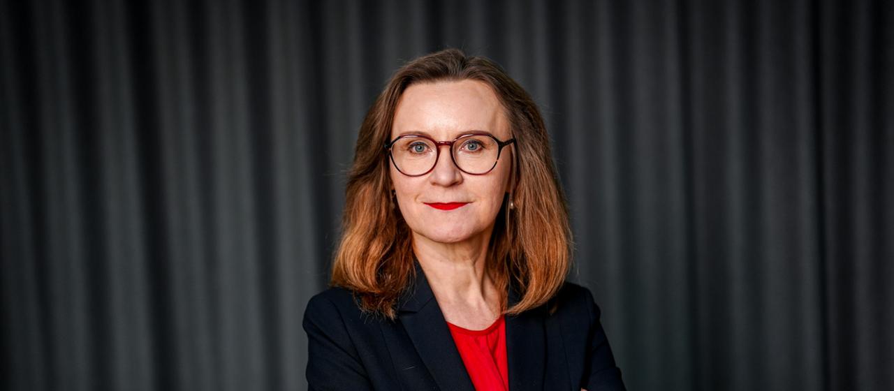 Sigrid Nikutta steht vor einem schwarzen Hintergrund
