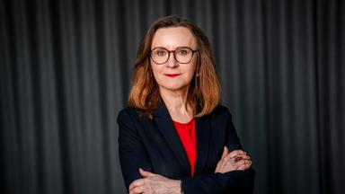 Sigrid Nikutta steht vor einem schwarzen Hintergrund