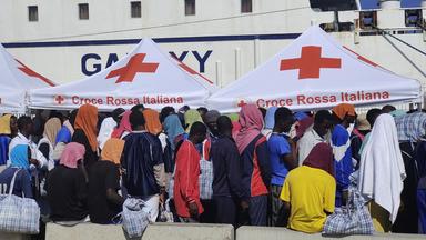 Migranten warten auf Lampedusa darauf, von der Insel weggebracht zu werden