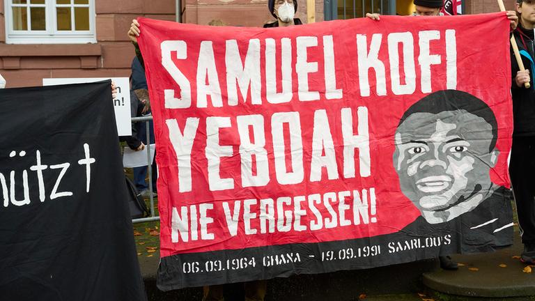 Demonstranten stehen vor dem Eingang des Oberlandesgerichts in Koblenz.
