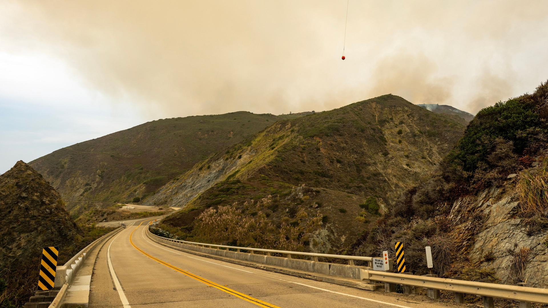Ein Hubschrauber fliegt über den Highway 1 in Kalifornien. | AP Photo/Nic Coury