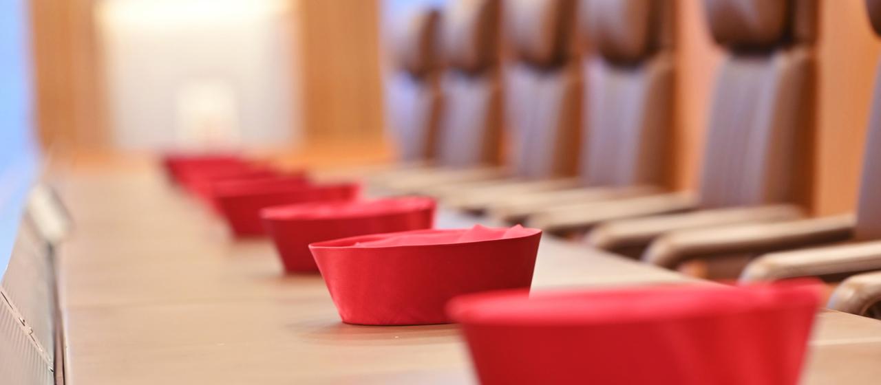 Auf der Richterbank im Sitzungssaal im Bundesverfassungsgericht liegen Barette der Bundesverfassungsrichter des ersten Senats.