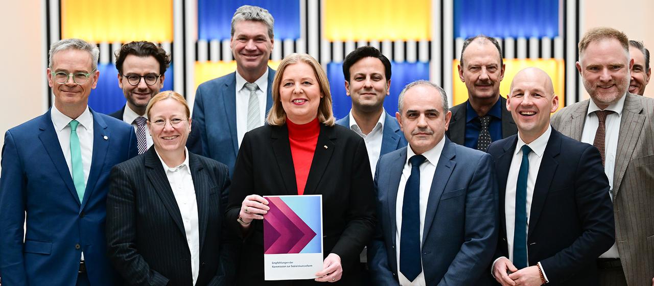 Bärbel Bas steht mit den Kommissionsmitgliedern im Arbeitsministerium.