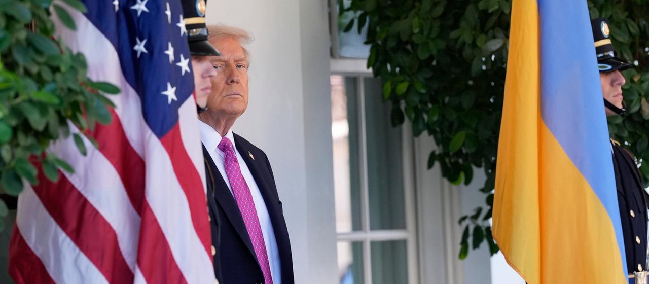 US-Präsident Trump steht zwischen einer amerikanischen und einer ukrainischen Flagge. | AP US-Präsident Trump steht zwischen einer amerikanischen und einer ukrainischen Flagge.