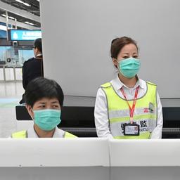 Mitarbeiter des Hongkonger Gesundheitswesens stehen mit Mundschutz an einem Bahnhof. Das Foto wurde vom Informationsdienst der Hongkonger Regierung veröffentlicht.