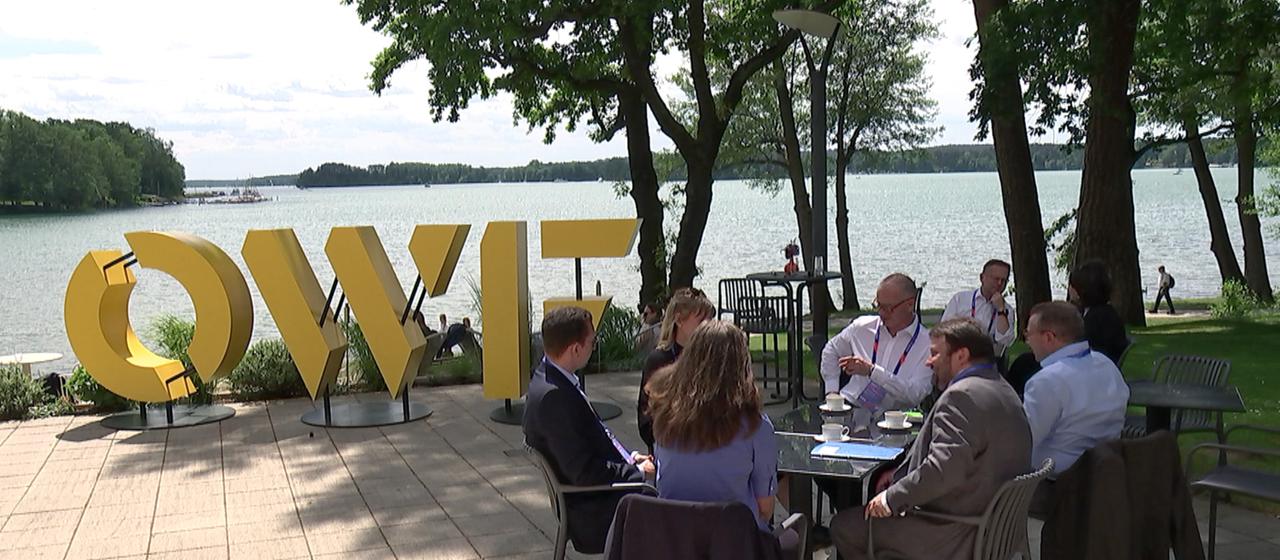 Schriftzug OWF vor einem See.