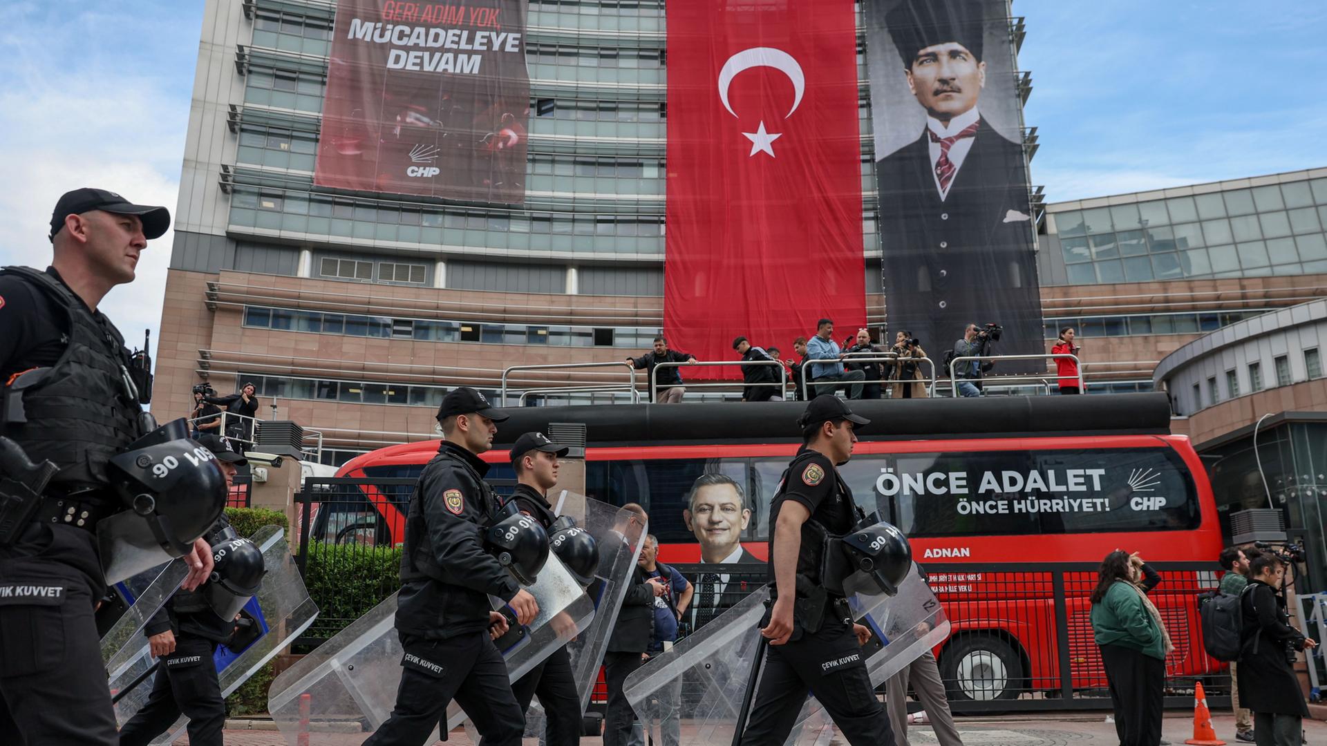 Polizisten marschieren mit Schutzschilden an einem Gebäude mit türkischer Flagge vorbei | Ugur Yildirim/Dia Photo via AP