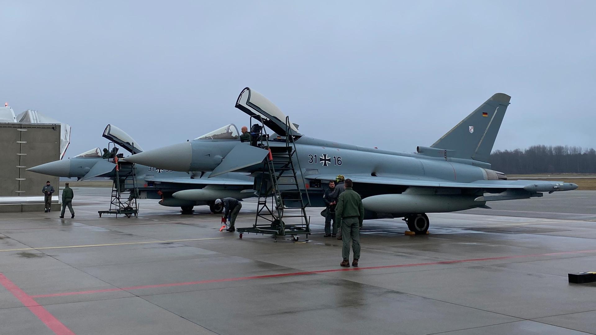 Personen stehen vor einem Eurofighter in Lettland | dpa