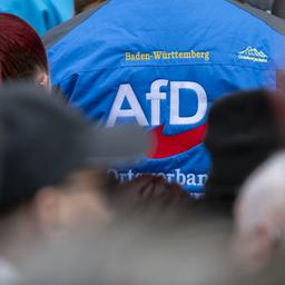 Ein Mann mit dem Logo der AfD