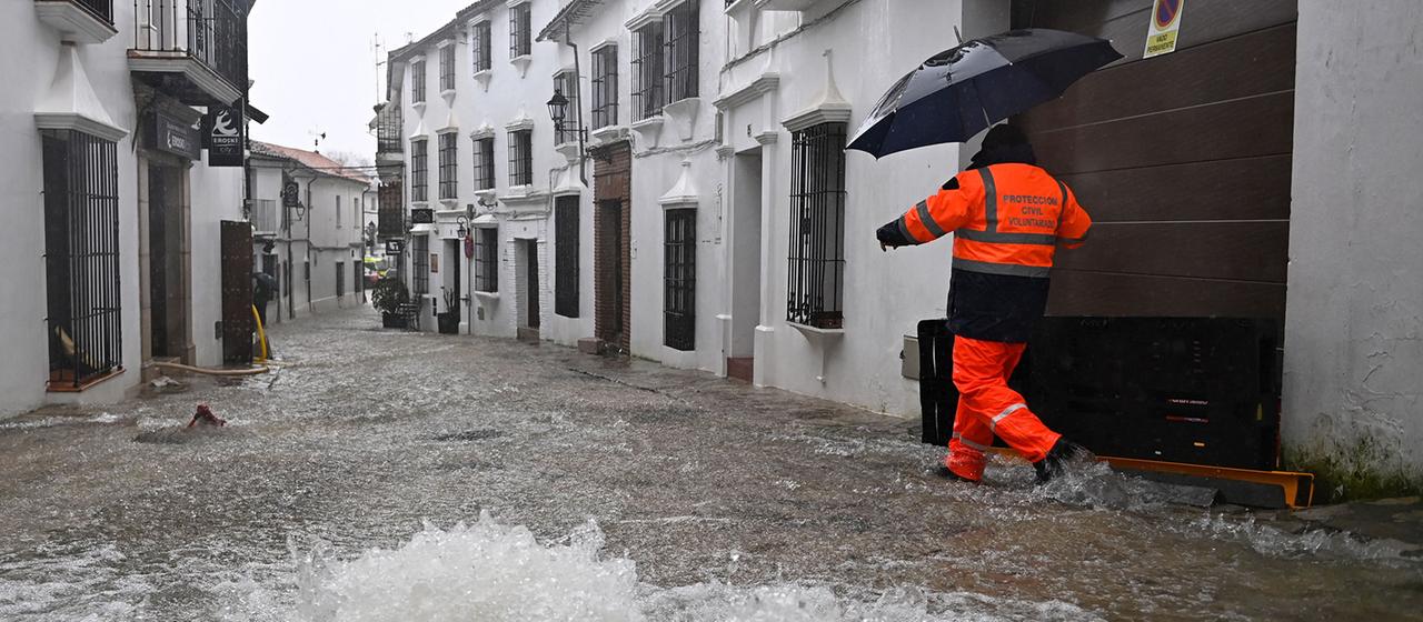 Ein Zivilschutzhelfer geht durch eine überflutete Straße in Grazalema (Spanien).