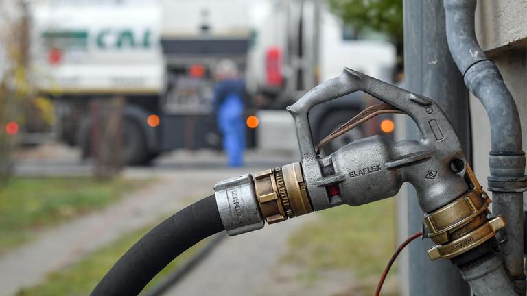 Über eine Zapfpistole wird ein Mehrfamilienhaus mit Heizöl betankt.