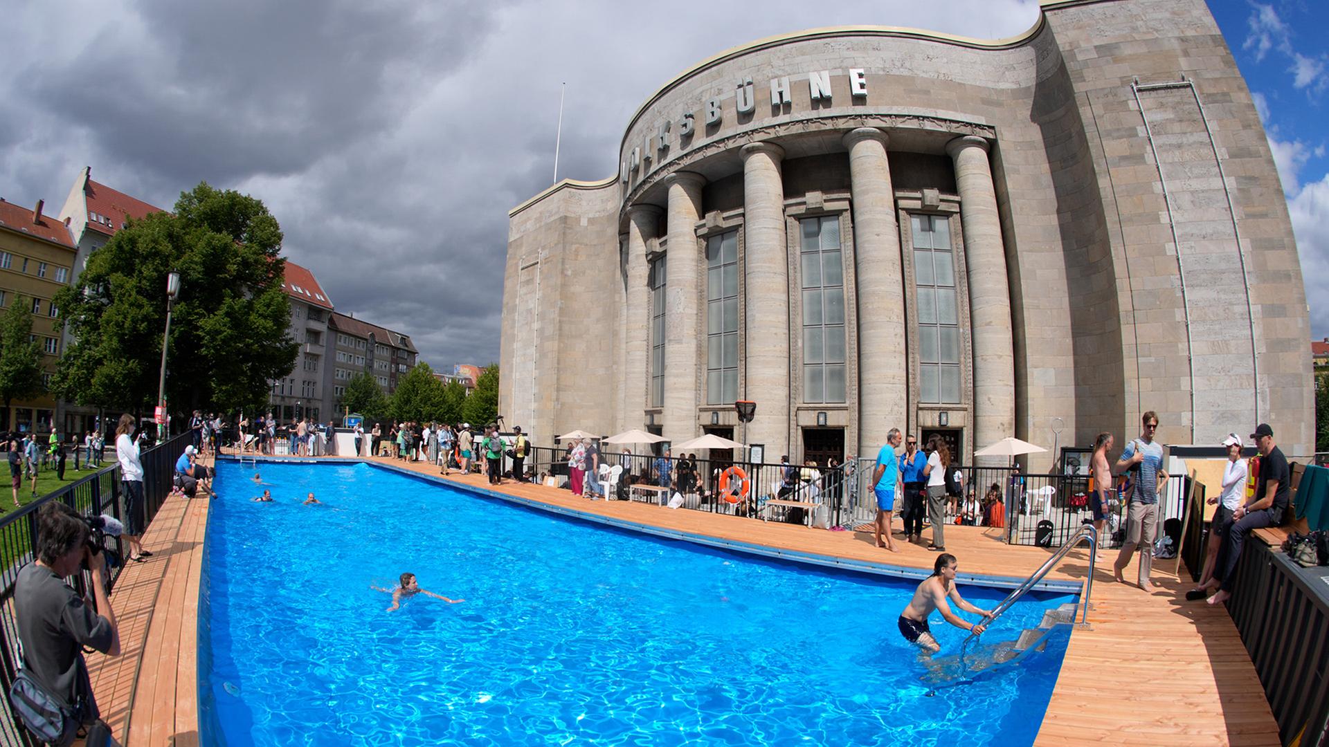 Erste Gäste schwimmen im Wasser des öffentlichen Schwimmbeckens vor der Volksbühne am Rosa-Luxemburg-Platz. (Quelle: picture alliancedpa/Soeren Stache) | picture alliancedpa/Soeren Stache