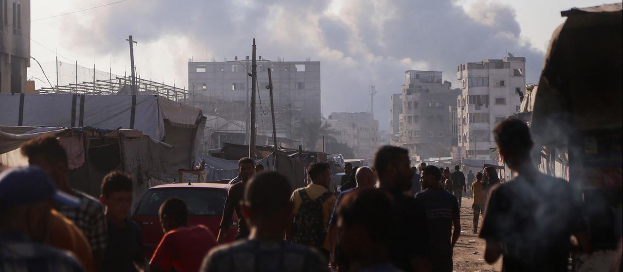 Menschen in Chan Yunis nach israelischen Angriffen vor Rauchschwaden und beschädigten Häusern | AFP Menschen in Chan Yunis nach israelischen Angriffen vor Rauchschwaden und beschädigten Häusern