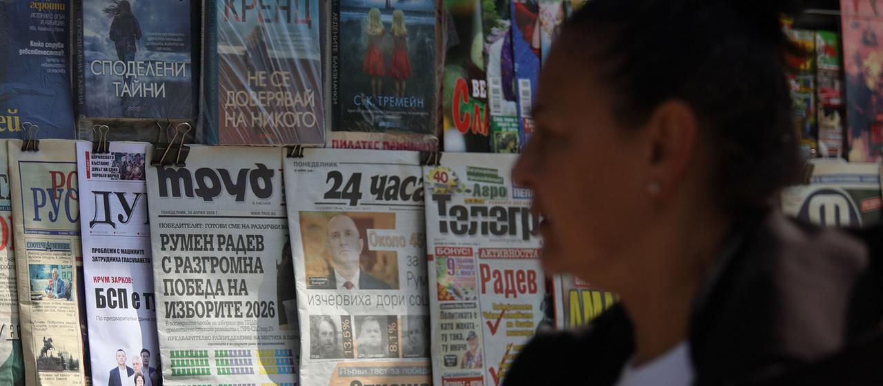 Eine Frau geht in Sofia (Bulgarien) an einem Stand mit Morgenzeitungen vorbei.