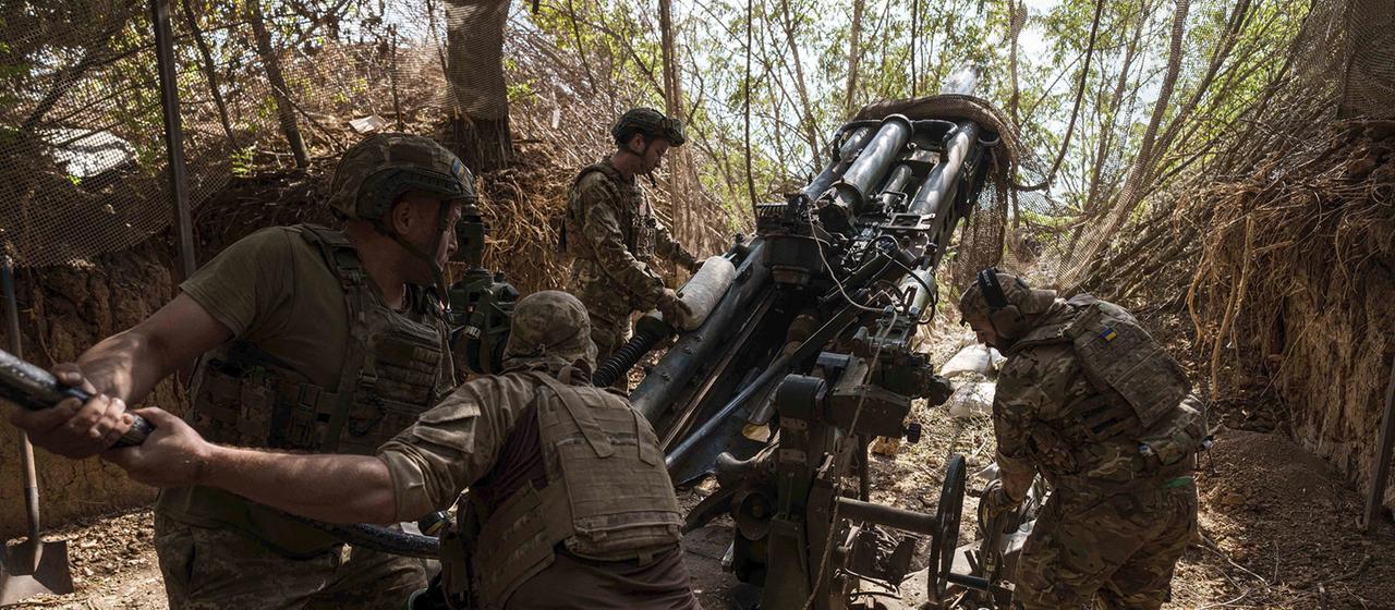 Ukrainische Soldaten laden Munition in eine M777-Haubitze an der Frontlinie in der Region Saporischschja.