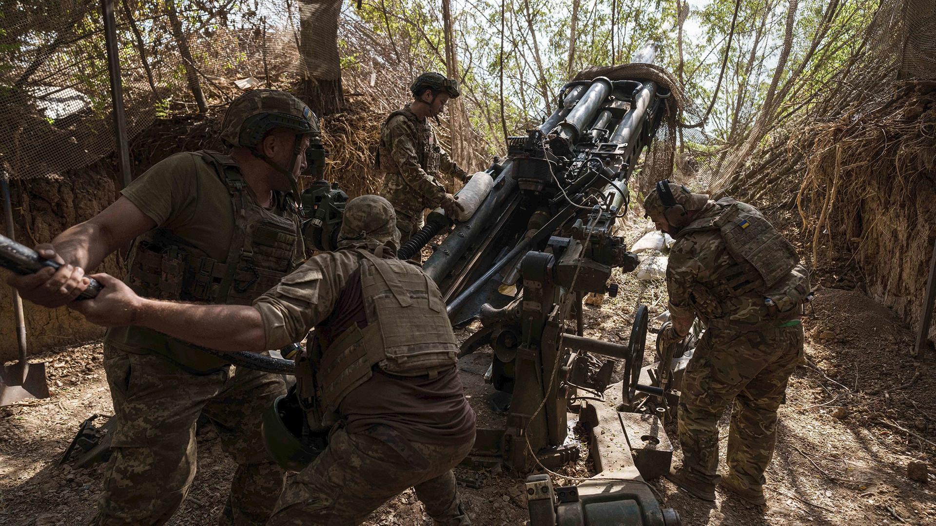 Ukrainische Soldaten laden Munition in eine M777-Haubitze an der Frontlinie in der Region Saporischschja. | AP