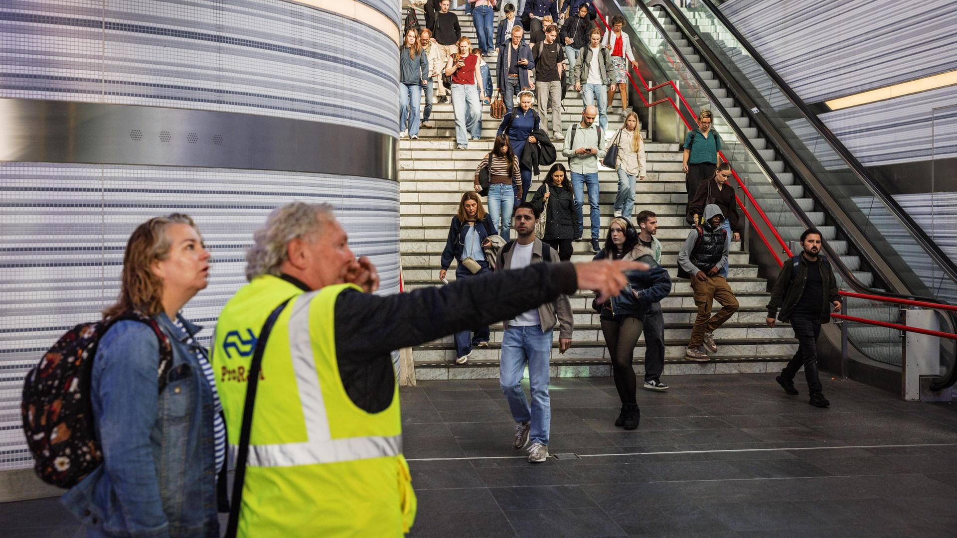 Ein Mitarbeiter der Niederländischen Eisenbahn hilft einem Fahrgast am Bahnhof Zwolle. | EPA