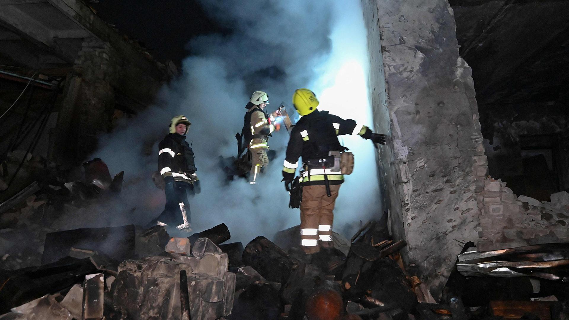 Feuerwehrleute löschen ein brennendes Haus. | AFP
