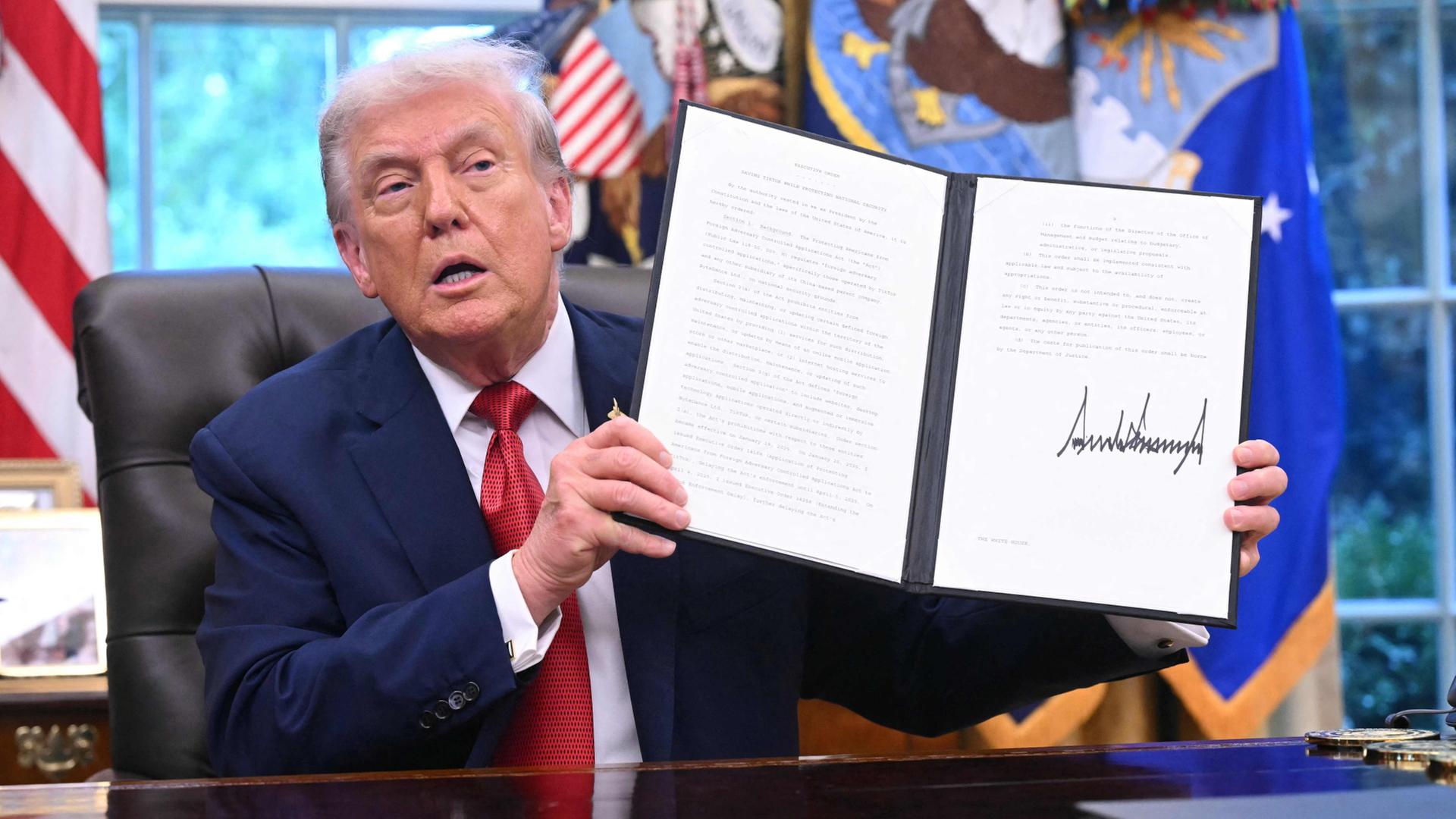 Donald Trump hält im Oval Office eine Präsidentenverfügung. | AFP