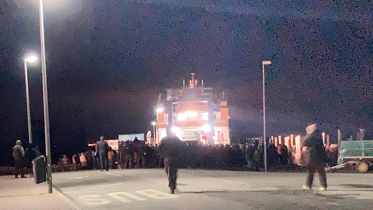 Bauern stehen in Schüttsiel vor einer Fähre.